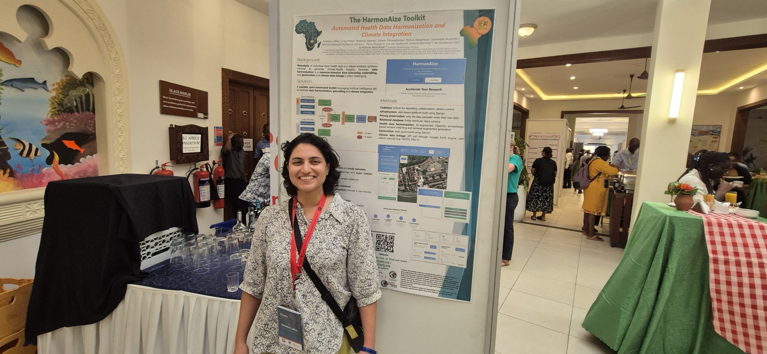 Natasha Lalloo standing beside The HarmonAIze Toolkit poster